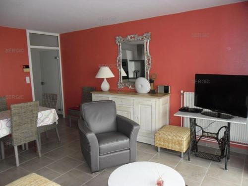 un salon avec une chaise et une télévision dans l'établissement Annonce de professionnel - Bel appartement, face Mer., au Crotoy