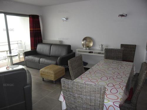 un salon avec une table et un canapé dans l'établissement Annonce de professionnel - Bel appartement, face Mer., au Crotoy