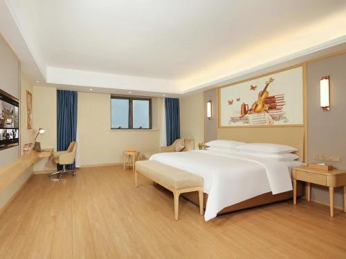 a bedroom with a large white bed in a room at Vienna International Hotel Wenchang in Wenchang