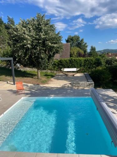 a swimming pool with blue water in a yard at Gite authentique au coeur de Blavozy avec piscine privée, jacuzzi et terrain de pétanque in Blavozy