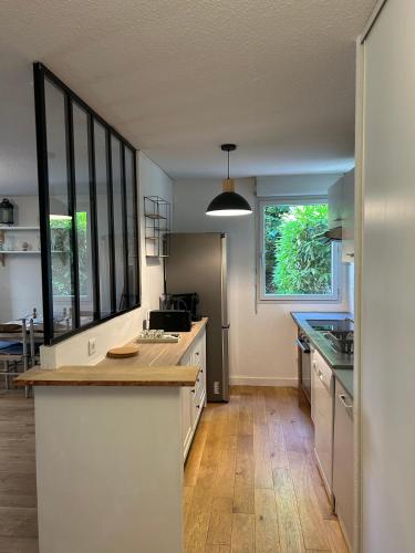 une cuisine avec un comptoir et une grande fenêtre dans l'établissement L'Émile Lécrivain parking facile, à Toulouse