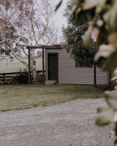 a shed with a door in a yard at Moomaa Stay in Marton