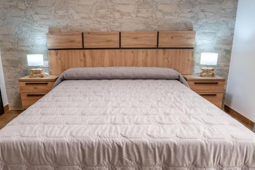 a bedroom with a large bed with two night stands at Les Gubies in Beceite