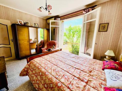 a bedroom with a large bed and a large window at Papi cocotte in Valréas