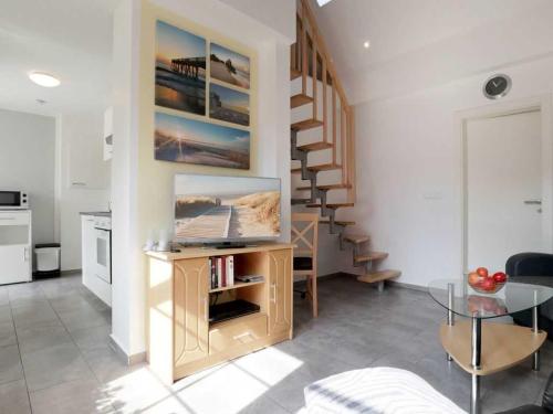 a living room with a table and a spiral staircase at Troja Ferienwohnung in Kalkhorst