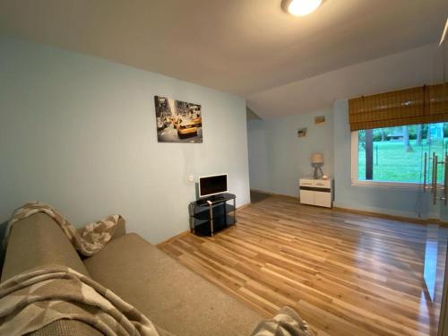 尤尔马拉Dune cottage的带沙发和木地板的客厅