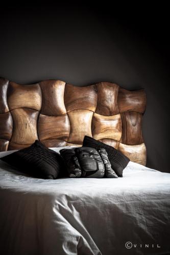 a wooden headboard of a bed with pillows on it at Villa Nao in Roxton Falls