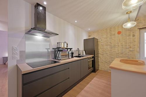 Il comprend une grande cuisine équipée d'un évier et d'une cuisinière. dans l'établissement Le loft du Cloître - Parking - Clim, à Avignon