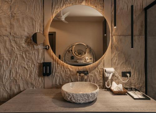 a bathroom with a stone sink and a mirror at Luxury Lofts in Amritsar
