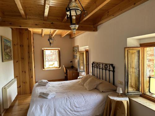 a bedroom with a large bed with a wooden ceiling at Casa rural C de Caballo, Valdorria Brother Law SL in Valdorria