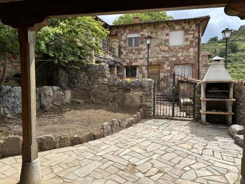 a stone house with a gate and a stone courtyard at Casa rural C de Caballo, Valdorria Brother Law SL in Valdorria