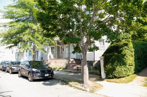 a car parked in front of a house with a tree at The Freedom HOME from HOME in New Bedford