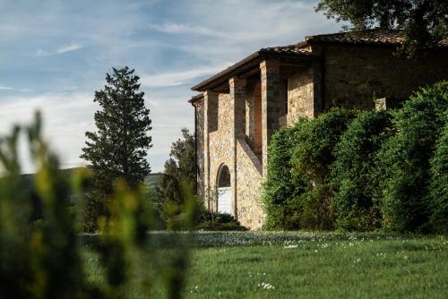 an old stone building with a door in a yard at Tenuta CastelGiocondo in Montalcino