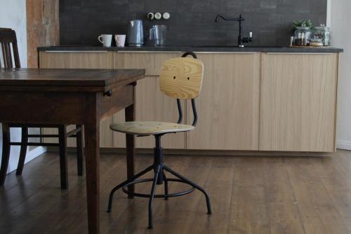 a wooden chair sitting in a kitchen next to a counter at Skrundas ielas apartamenti in Kuldīga