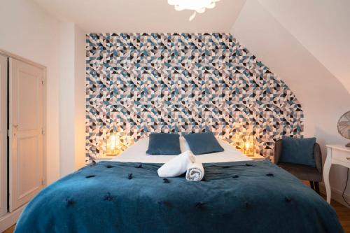 een slaapkamer met een blauw bed en een groot hoofdeinde bij Le prestige de Poincare in Nancy