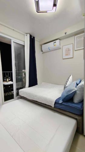 a bedroom with a large bed and a window at Harmonious Hideaway in Lapu Lapu City