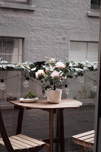 a table with a potted plant on a patio at Collins Paris End suite- 2 bedrooms with balcony in Melbourne