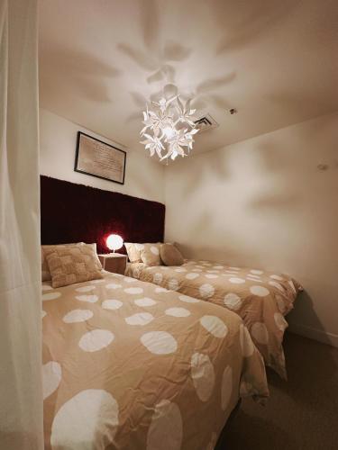 a bedroom with a large bed and a chandelier at Collins Paris End suite- 2 bedrooms with balcony in Melbourne