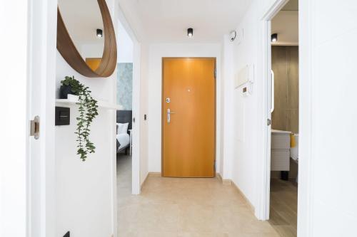 pasillo con puerta marrón y paredes blancas en Apartamento Palermo Living Suites en Burriana, en Burriana