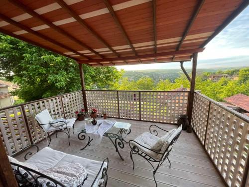 a wooden deck with chairs and a table on it at Ethno Villa Cherry in Cherven