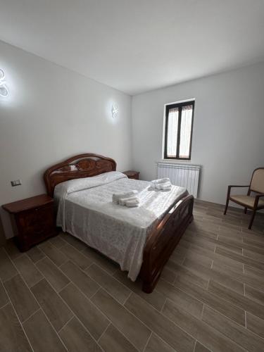 a bedroom with a bed and a chair and a window at Il Pergolato in Aielli