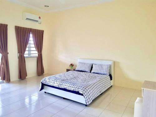 a bedroom with a bed and a window at Lovely Homestay in Gerik with Free Netflix & WiFi in Gerik