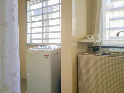 a small kitchen with a small refrigerator and a window at Lovely Homestay in Gerik with Free Netflix & WiFi in Gerik