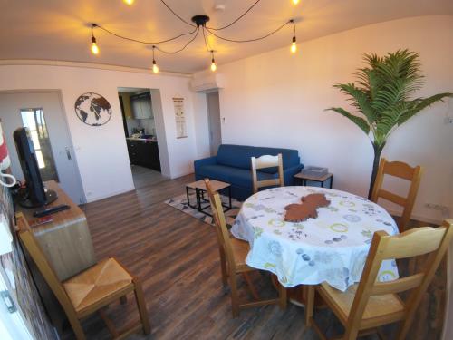 un salon avec une table et un canapé bleu dans l'établissement résidence Valport T3 4 pers 2 chambres, à Valras-Plage