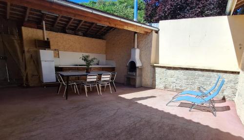 une terrasse avec une table, des chaises et une cuisinière dans l'établissement maison avec terrasse du valleroy, à Joinville