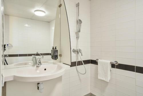 a white bathroom with a sink and a shower at ibis budget Issy Les Moulineaux Paris Ouest in Issy-les-Moulineaux