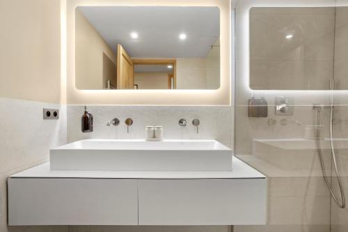 une salle de bain blanche avec un lavabo et un miroir dans l'établissement Magnifique appartement St Tropez, à Saint-Tropez