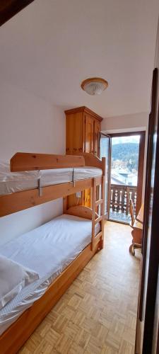 1 dormitorio con 2 literas y balcón en Appartamento Cialuzin, en Pieve di Cadore