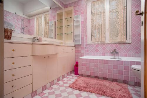 フィウミチーノにあるLa casetta di Ily e Giulyのピンクのバスルーム(バスタブ、シンク付)