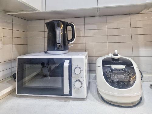 a coffee maker and a microwave on a counter at Have Stay in Gumi