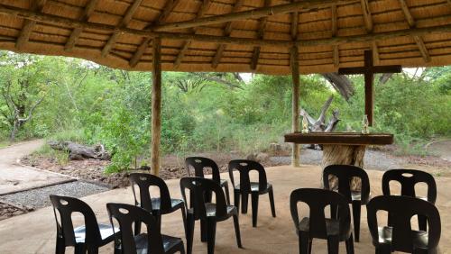 a group of black chairs sitting under a pavilion at Muchenje Self Catering Cottages in Muchenje