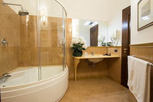 a bathroom with a bath tub and a sink at Hotel Della Valle in Agrigento