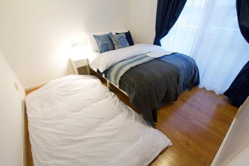 a small bedroom with a bed and a window at YAMASHIRO House in Ginowan
