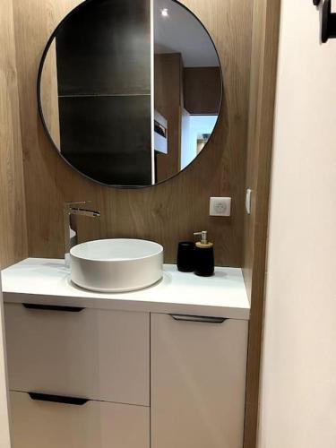 une salle de bain avec un lavabo et un miroir dans l'établissement Maison en bord de mer, à Lumio
