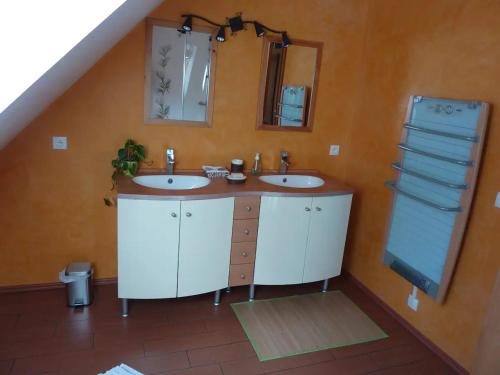 a bathroom with two sinks and a mirror at chez Marie et Eric in Dieffenbach-au-Val