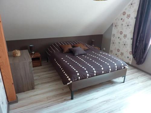 a bedroom with a bed and a wooden floor at chez Marie et Eric in Dieffenbach-au-Val