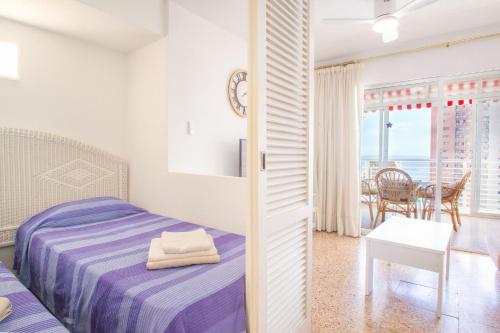 a bedroom with a bed and a table and a dining room at Serisol Holidays in Benidorm