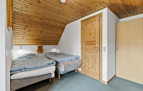 two beds in a room with a wooden ceiling at Beautiful Home In Aakirkeby With Wifi in Spidsegård