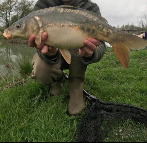 a person holding a fish in their hands at Spacious Lodge With Hot Tub in Lincolnshire