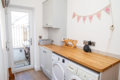 una cocina con lavadora y secadora en una encimera en Derwen House Newport, Pembrokeshire, en Newport