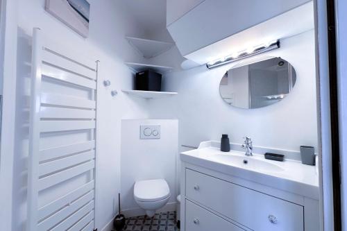 une salle de bain blanche avec un lavabo et un miroir dans l'établissement ALGER - Rooftop avec 1 chambre au centre-ville d'Antibes, à Antibes