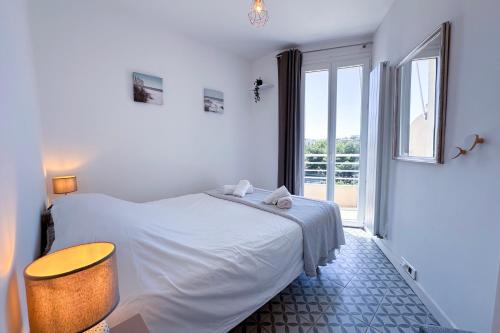 une chambre blanche avec un lit et une fenêtre dans l'établissement ALGER - Rooftop avec 1 chambre au centre-ville d'Antibes, à Antibes