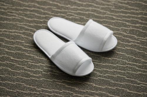 a pair of white slippers sitting on a carpet at Kobe Motomachi Tokyu REI Hotel in Kobe