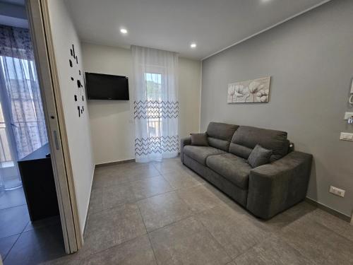 a living room with a couch and a television at Flowers Apartments in Marineo