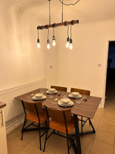 Un comedor con mesa y sillas de madera. en Stylish Miners Cottage, Treorchy, Rhondda, en Treorky