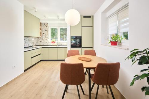 a kitchen with a wooden table and chairs at Apartman Tomi in Umag